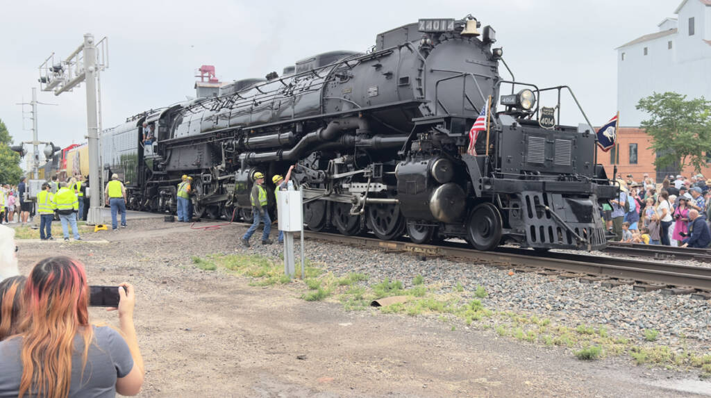 Large steam locomotive surrounded by spectators