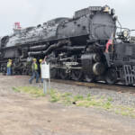 Large steam locomotive surrounded by spectators