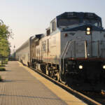 Passenger train led by road-switcher style locomotive