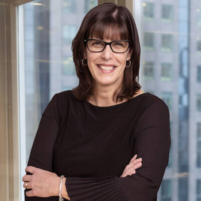 Woman standing in front of window with office building in background