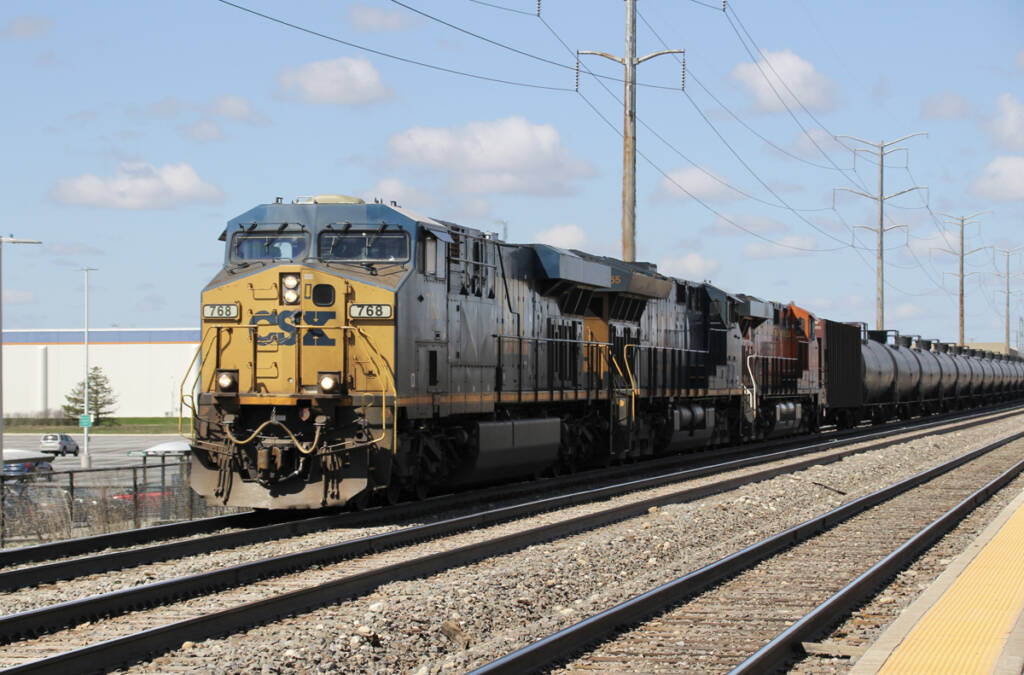 Two blue and yellow locomotives leading train of tank cars