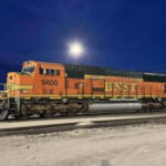 Orange, green, and yellow locomotive at night
