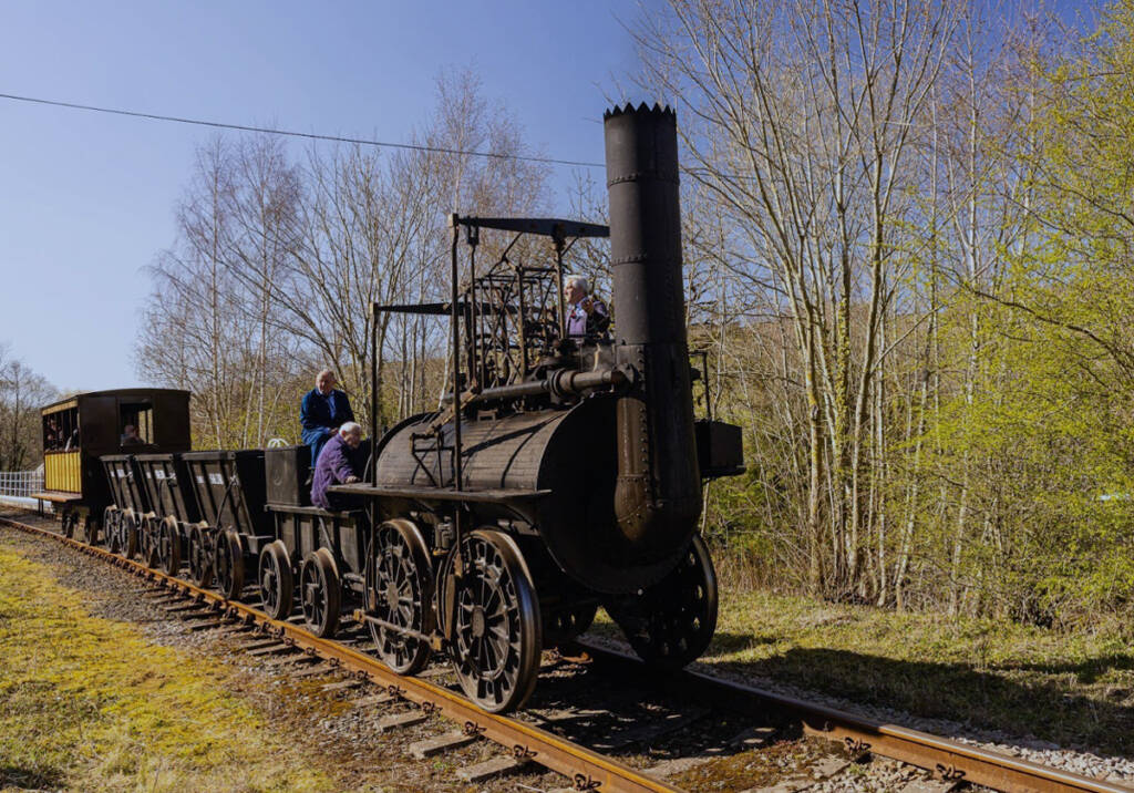 Replica of early steam locomotive with coach and coal hoppers