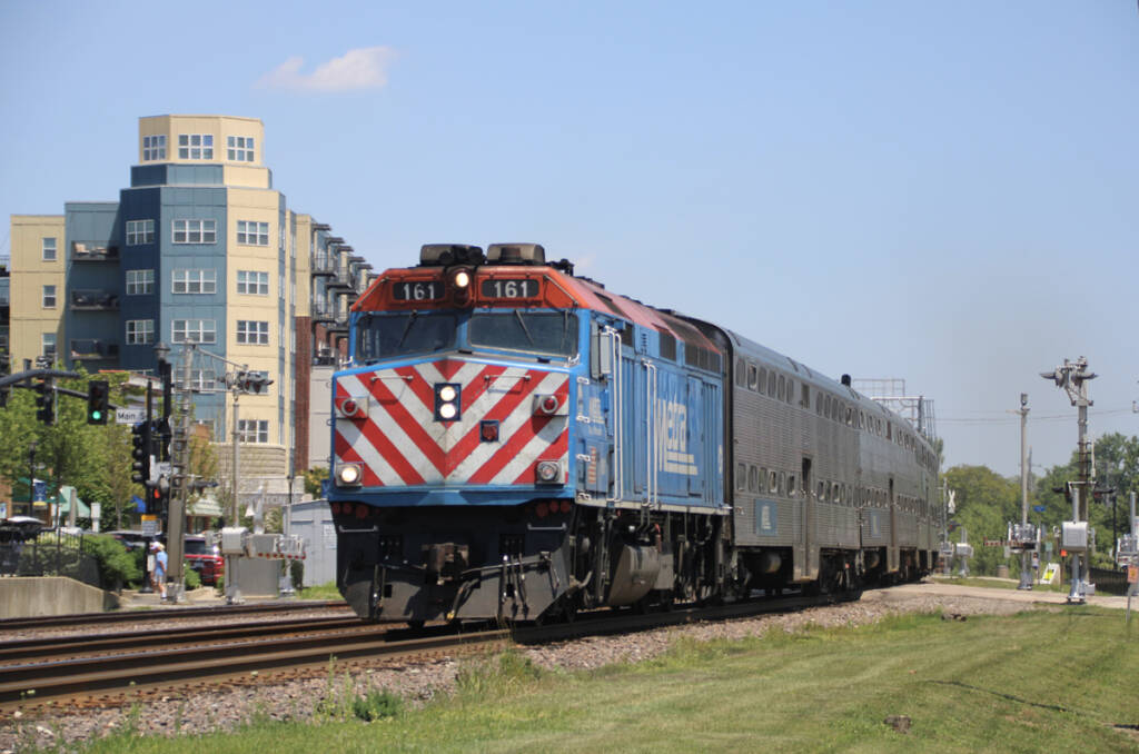 Commuter train on curve with multistory buildings in background
