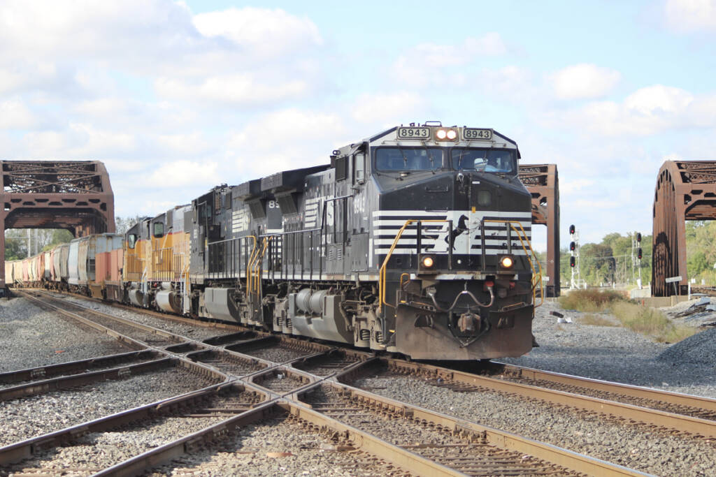 Freight train at diamond with bridges in background