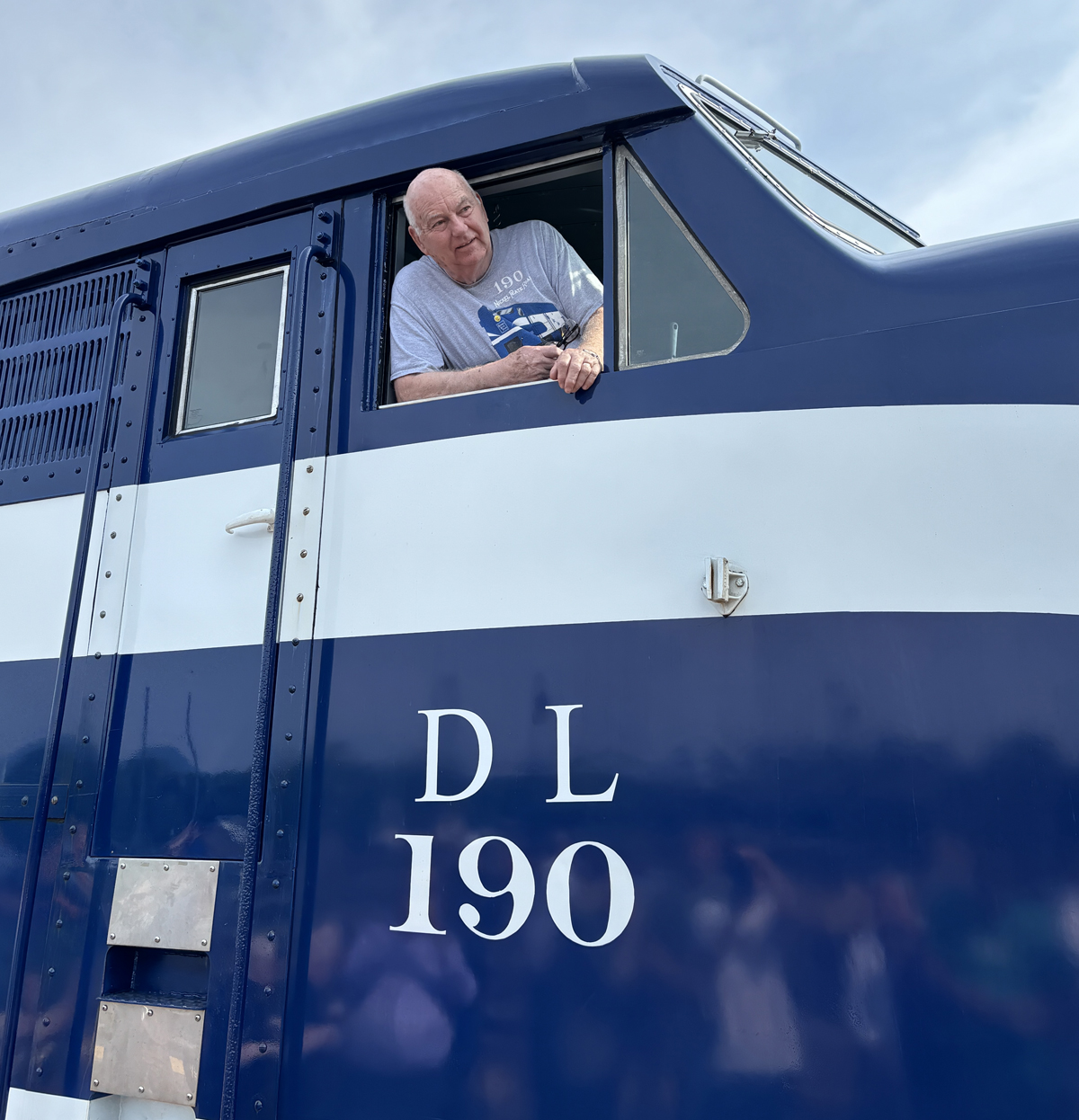 Man in cab of blue and white diesel