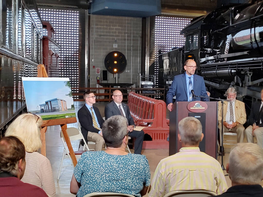 Group of people listening to speaker in railroad museum building