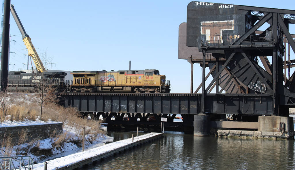 Train crossing bridge over canal