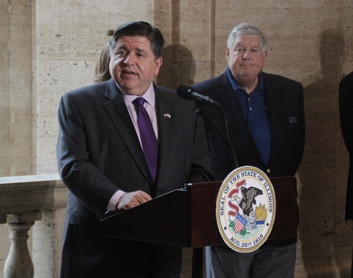 Man speaking at podium with Illinois state seal