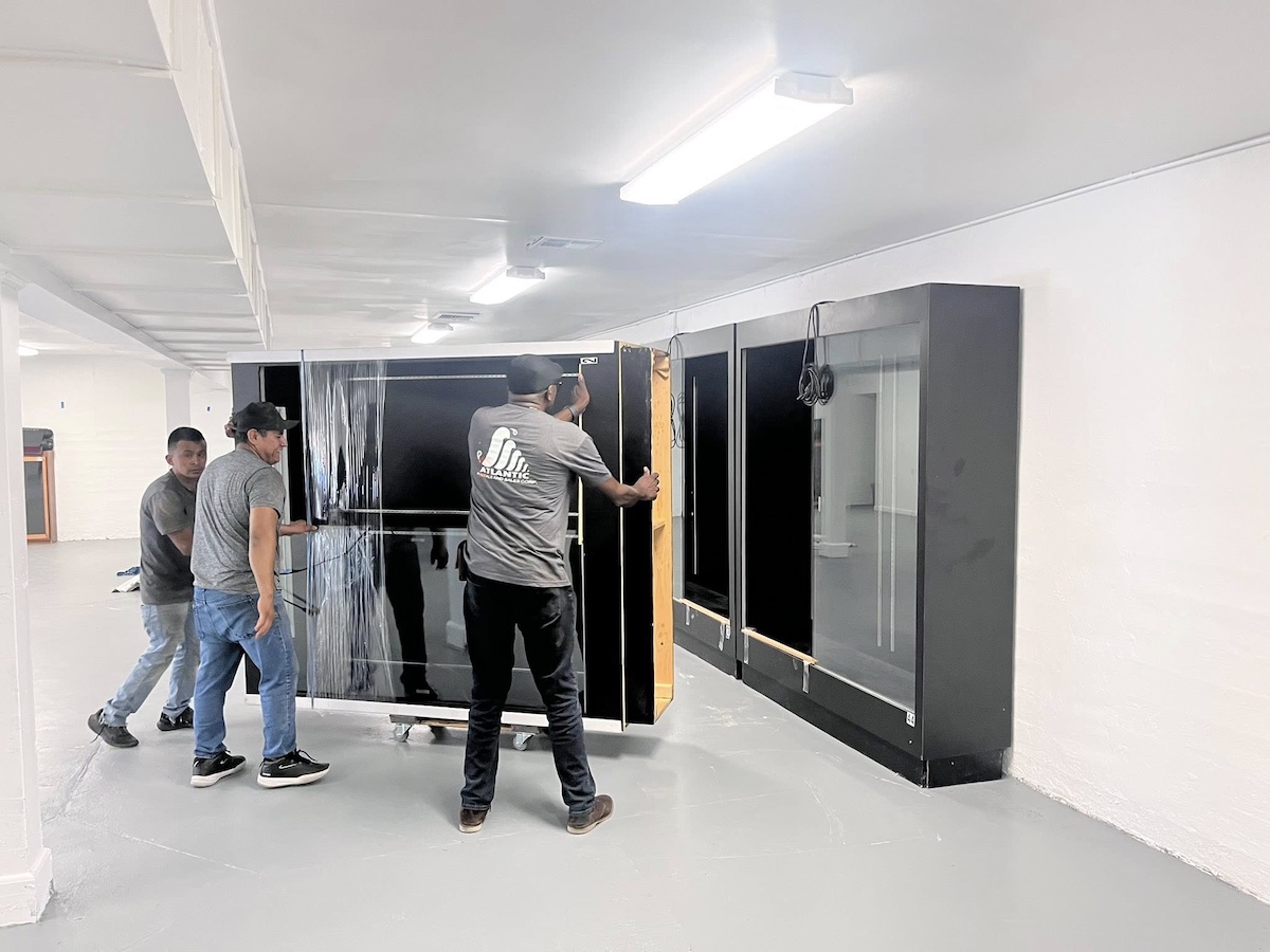 A few people moving large cabinets