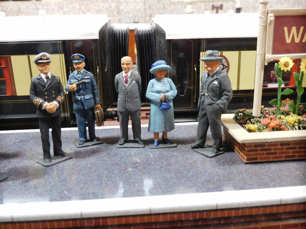 five figures on toy train layout