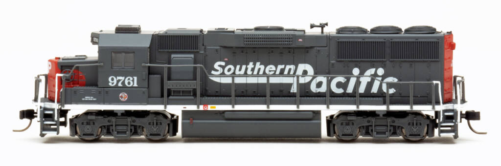 Color photo showing side view of N scale hood unit painted scarlet and gray on white background.
