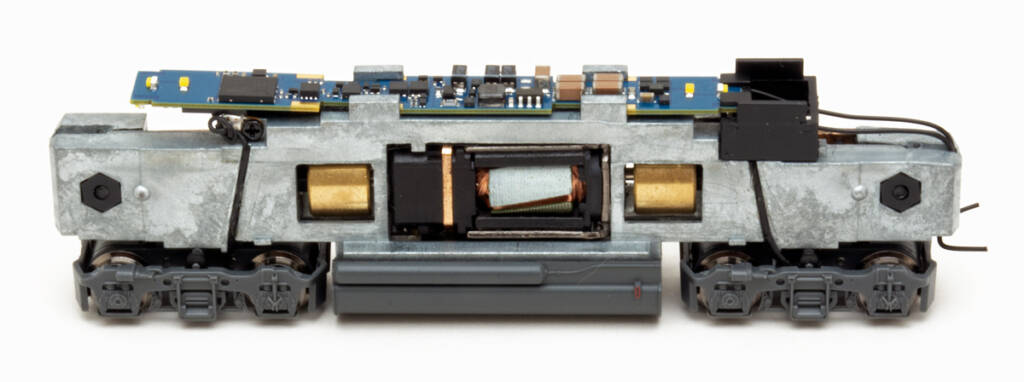 Color photo showing mechanism of N scale locomotive on white background.