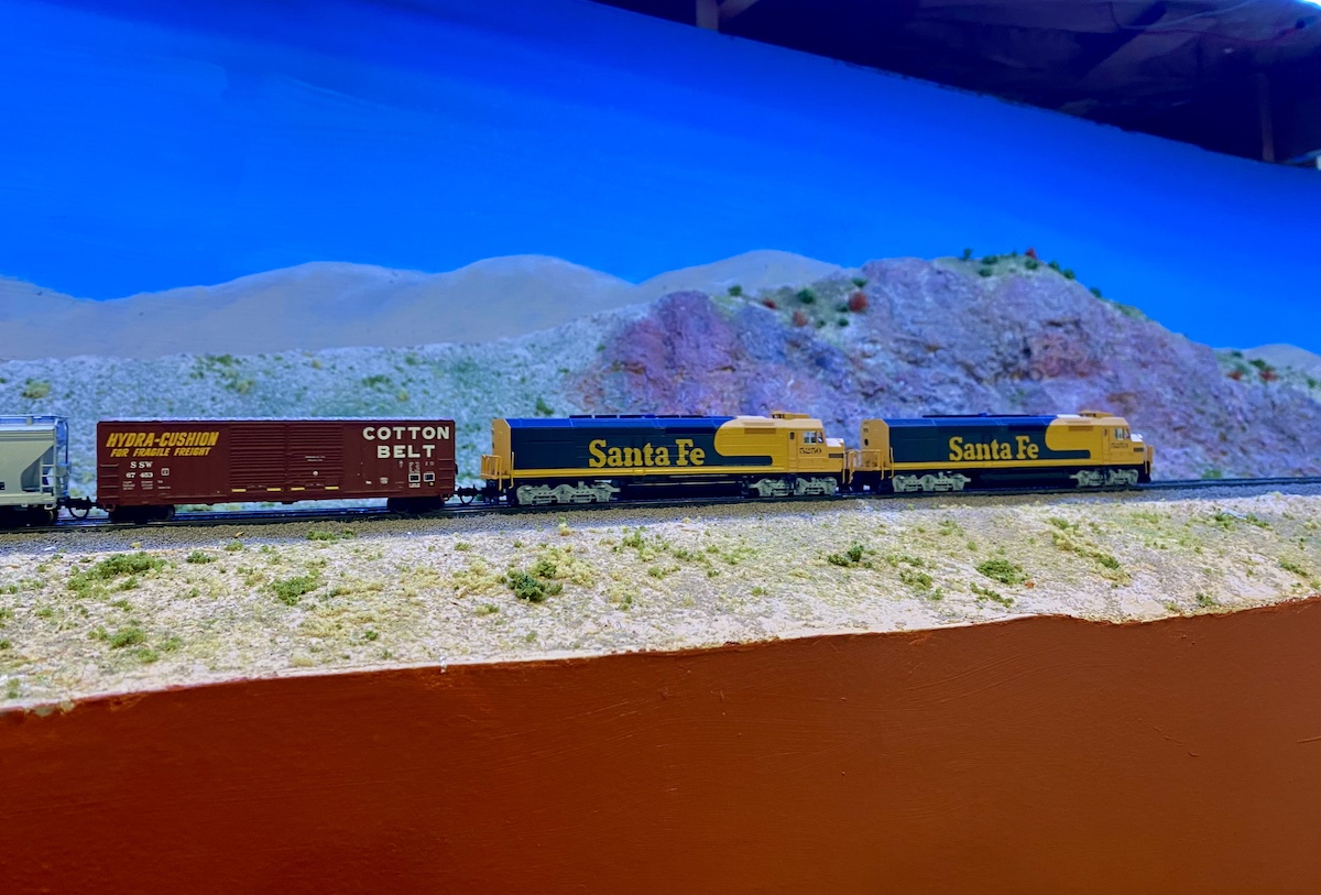 N scale train crosses a desert
