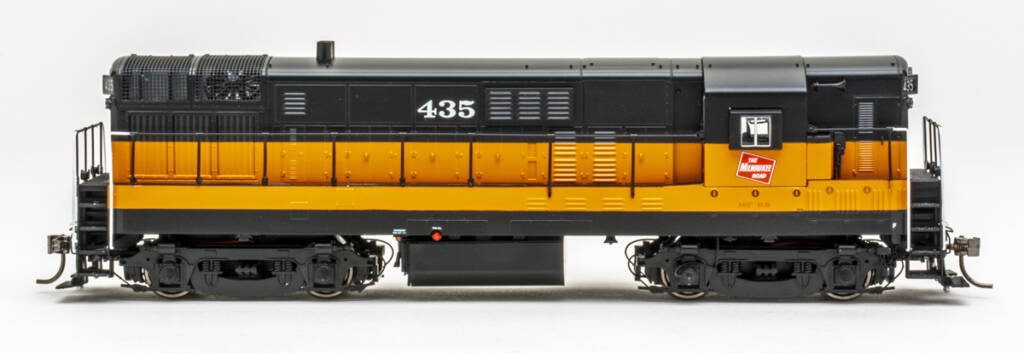 Photo showing side of HO scale diesel painted orange and black on white background.