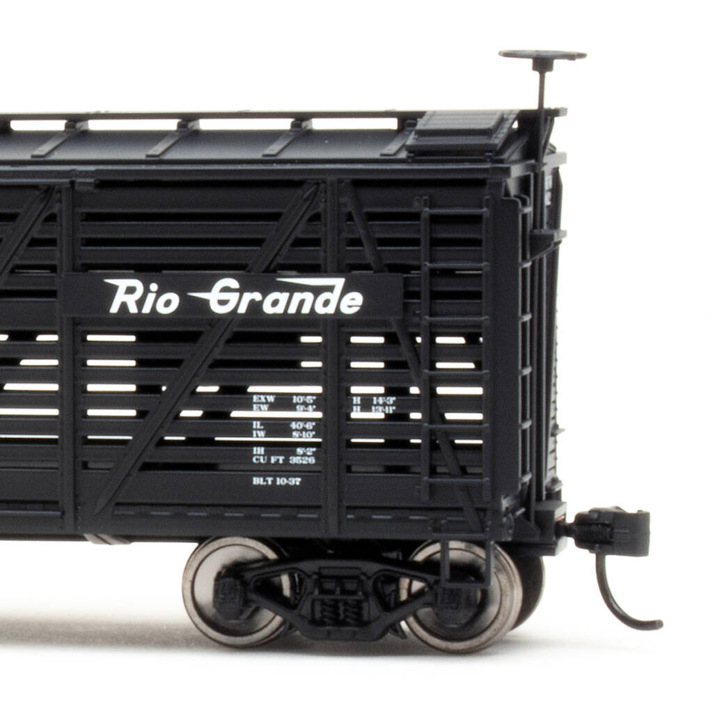 Color photo showing B end of HO scale stockcar painted black with white graphics on white background