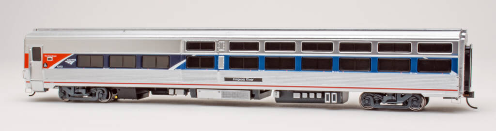 Color photo of HO scale modern passenger car with metal finish; tinted windows; and red, white, and blue graphics on white background. 