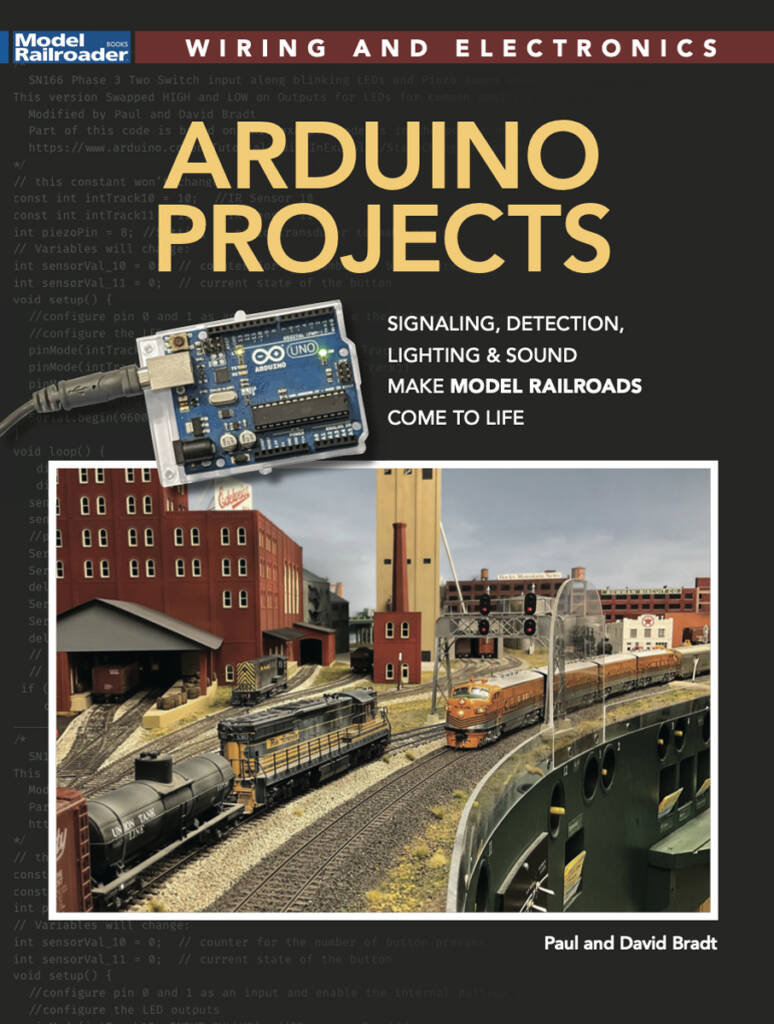 The cover for Arduino Projects from Model Railroader magazine which features two model trains on a model railroad layout