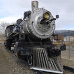 Black and silver steam locomotive inside fence. Butte restores NP No. 25
