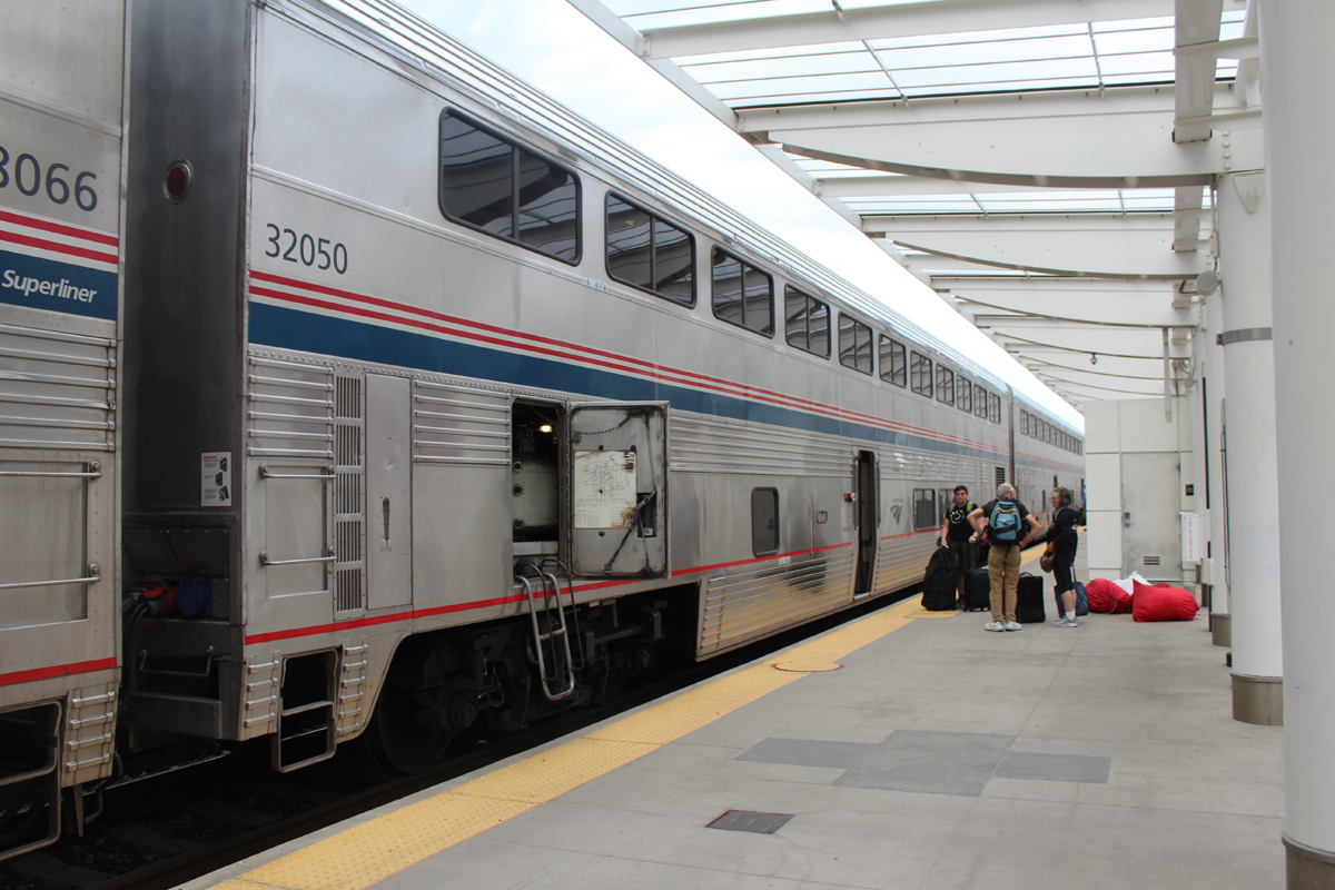 Passenger car with door open for maintenance during stop at station