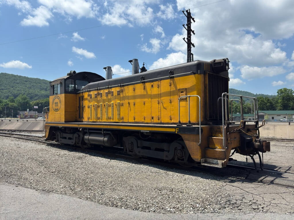 Three-quarters angle image of yellow end-cab switcher with black trim