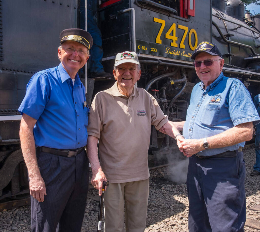 Three men in front of locomotive