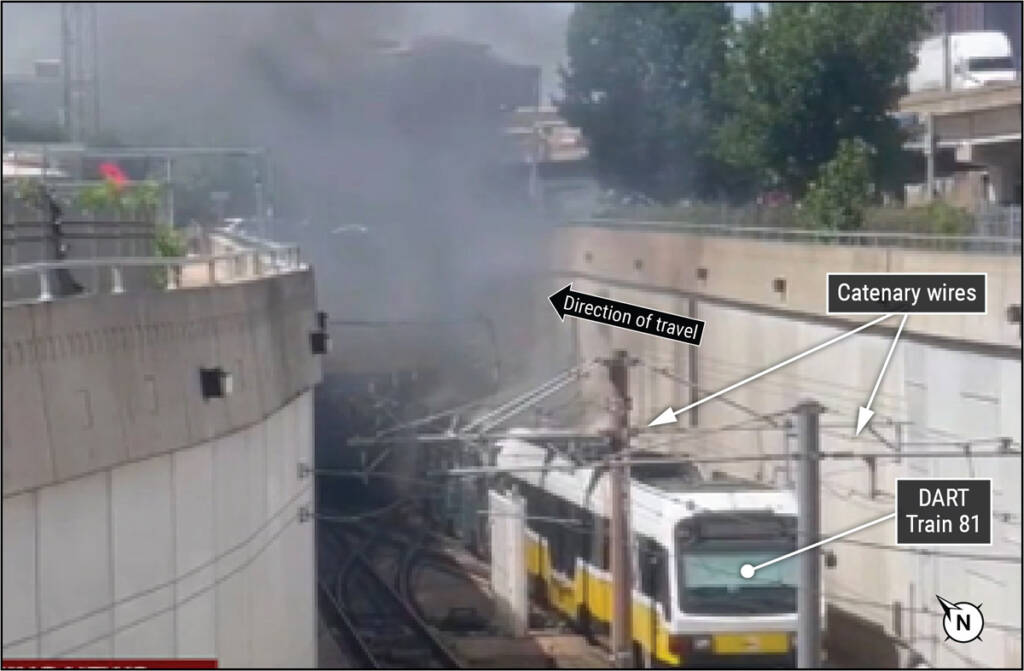 Image of smoke coming from light rail tunnel with stopped train in foreground