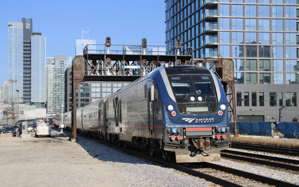 Passenger train passing under signal bridge