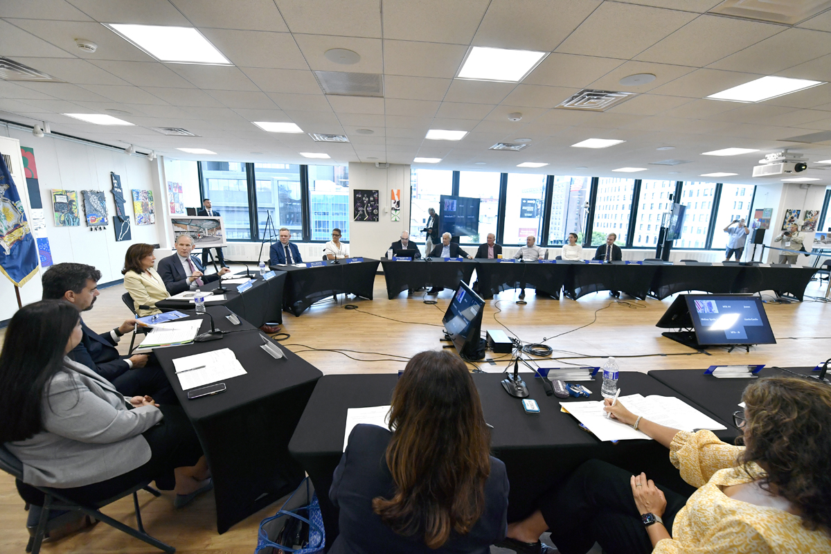 Large group meeting in room with wall of windows