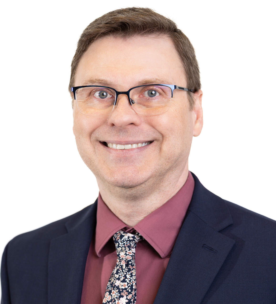 Smiling man in black coat and maroon shirt with tie.