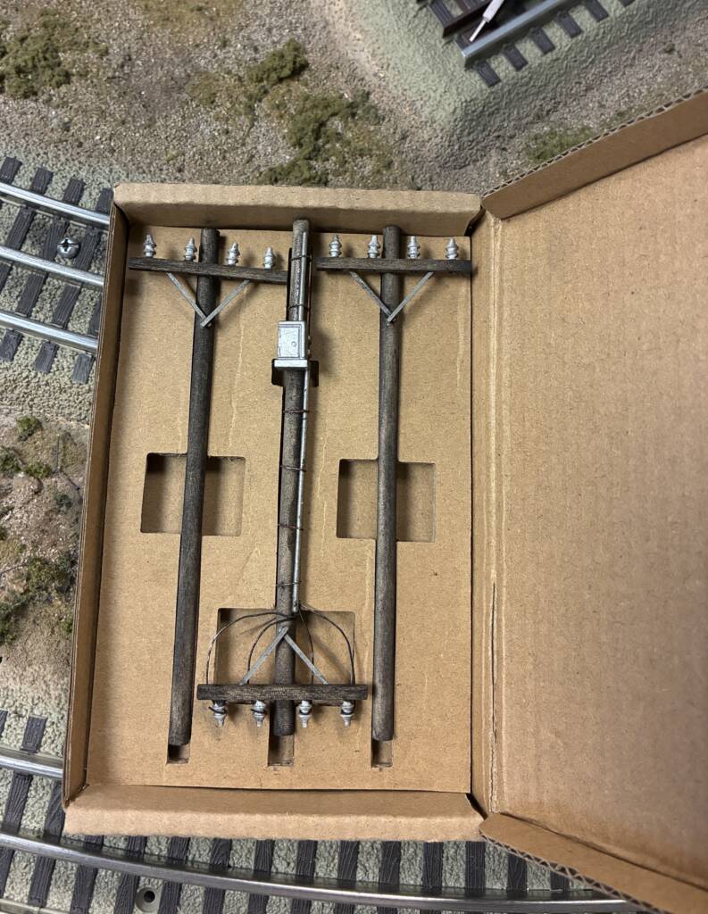 small box with three model telephone poles