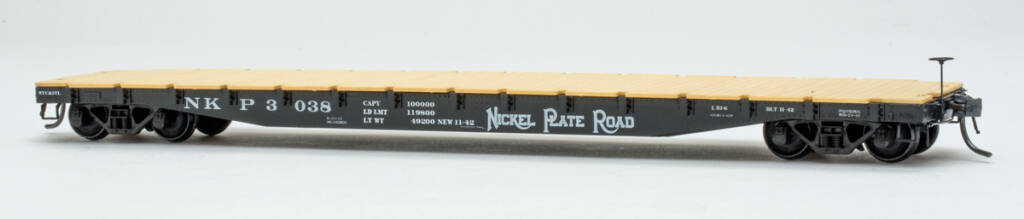 Color photo of HO scale flatcar painted black with white graphics and tan deck on white background