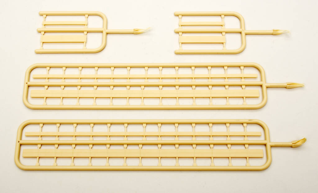 Color photo of tan plastic parts attached to sprues shown on white background.