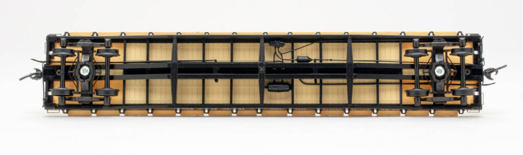 Color photo showing underbody of HO scale flatcar on white background.
