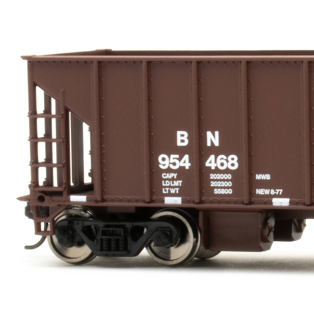 Color photo showing part of HO scale ballast hopper painted mineral red with white graphics on white background.