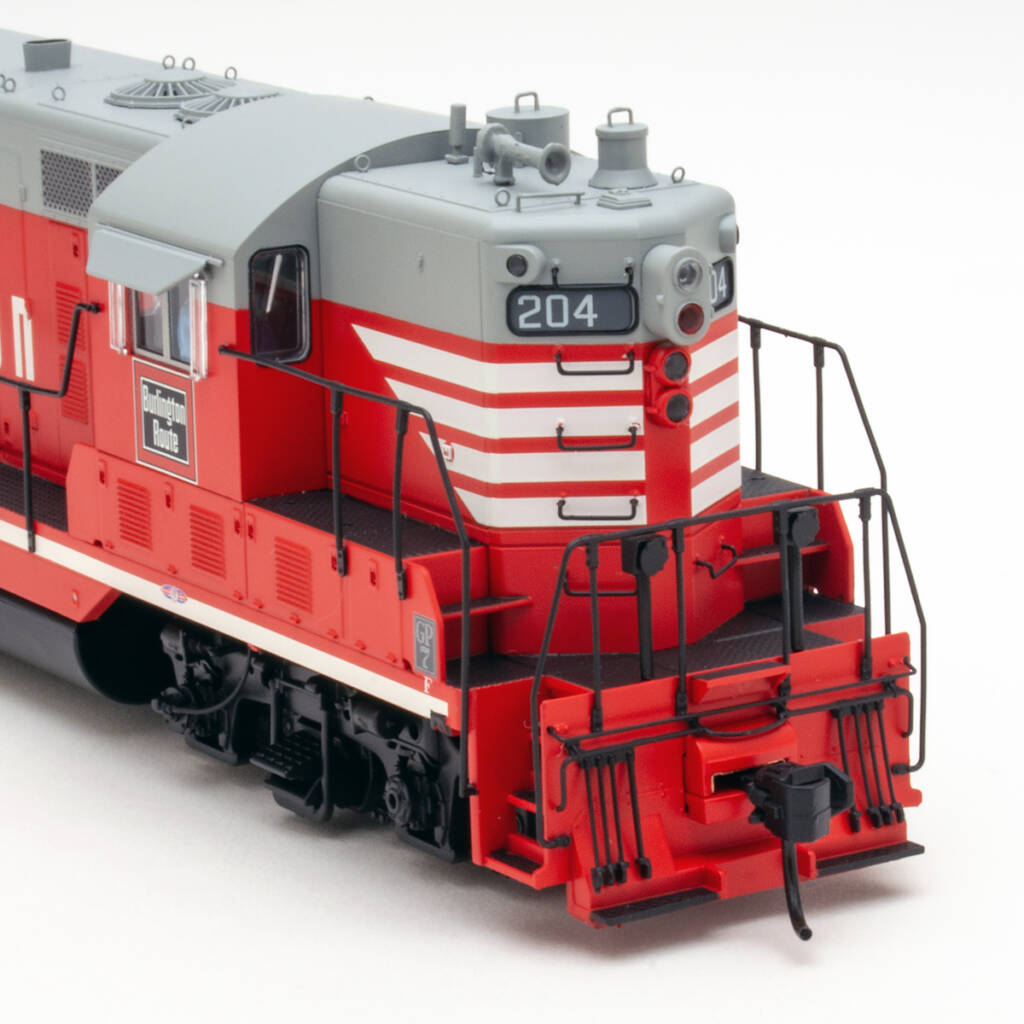 Color photo showing front of HO scale hood unit painted red and gray with red, white, and black graphics on white backdrop.