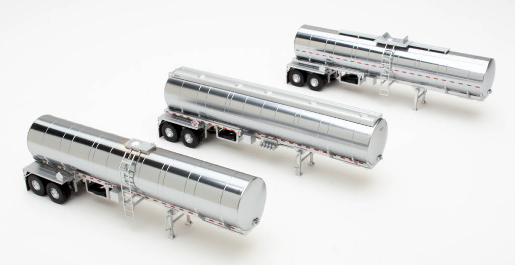 Color photo showing three HO scale tanker trailers with plated finish, red-and-white stripes, spare tire, and dual rear axles. 