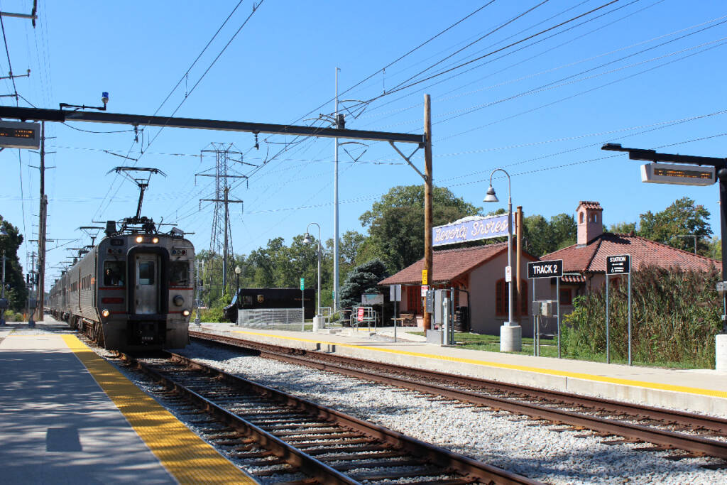 Electric train arrives at historic station building.