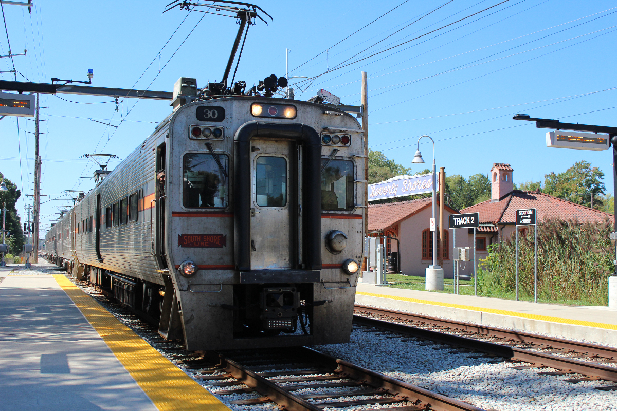 Electric interurban train arriving at historic station.