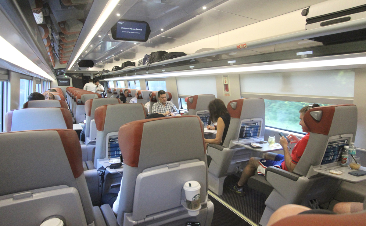 Interior of passenger car, with two seats on one side of aisle and one seat on the other.