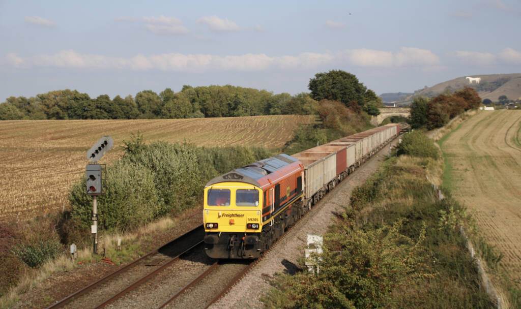 Orange, yellow, and black double-cab diesel on freight train