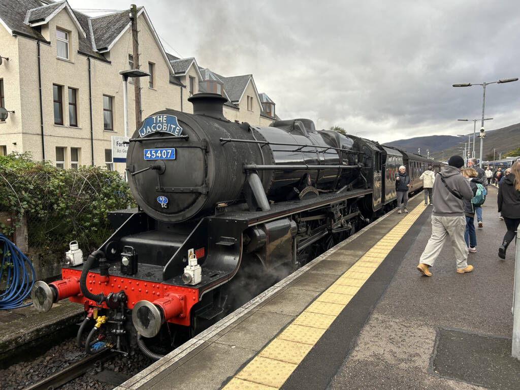 Black British steam locomotive at station