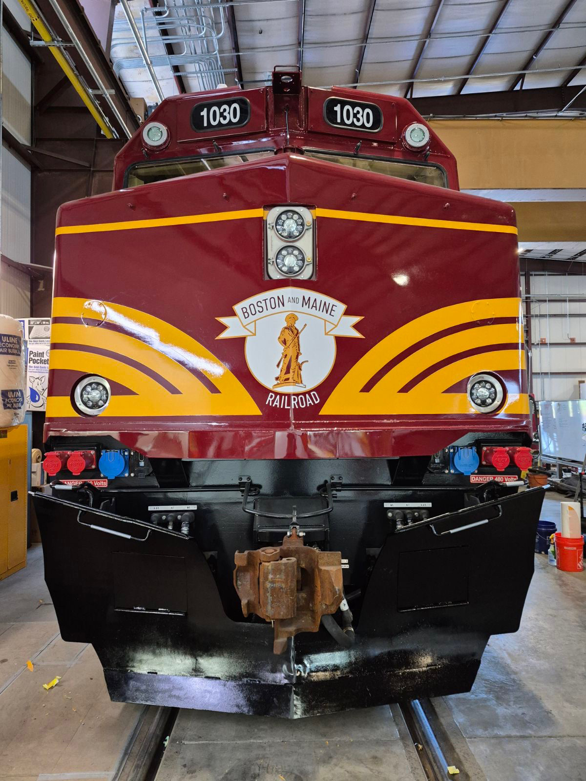 Front view of marron and gold commuter locmotive