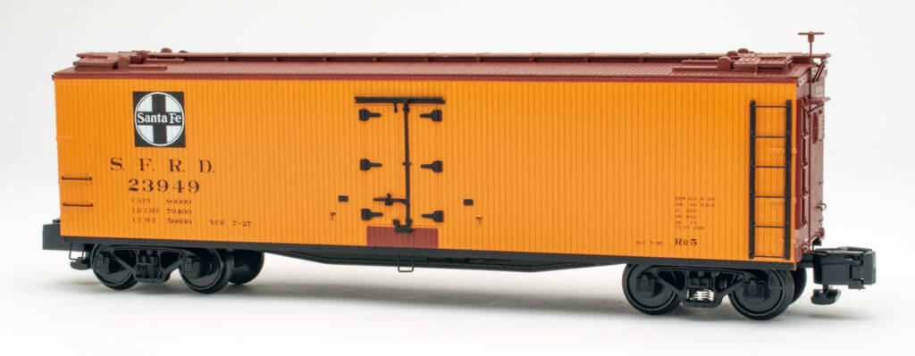 S gauge wood refrigerator car painted yellow-orange, mineral brown, and black with black and white graphics on white background.