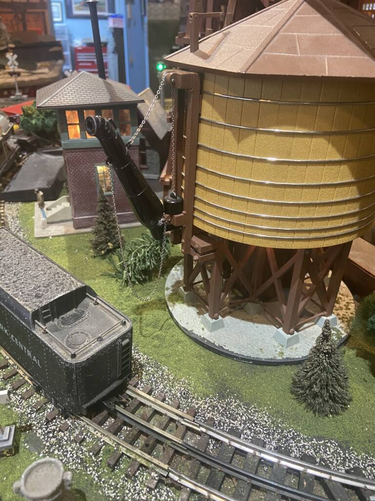 water tower next to tender on toy train layout
