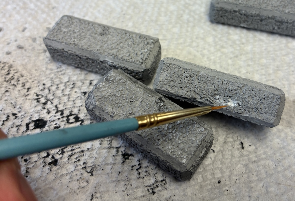 paintbrush adding white paint to block