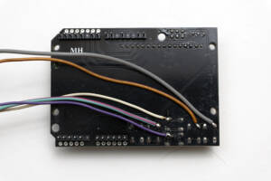 back of black circuit board with wires attached