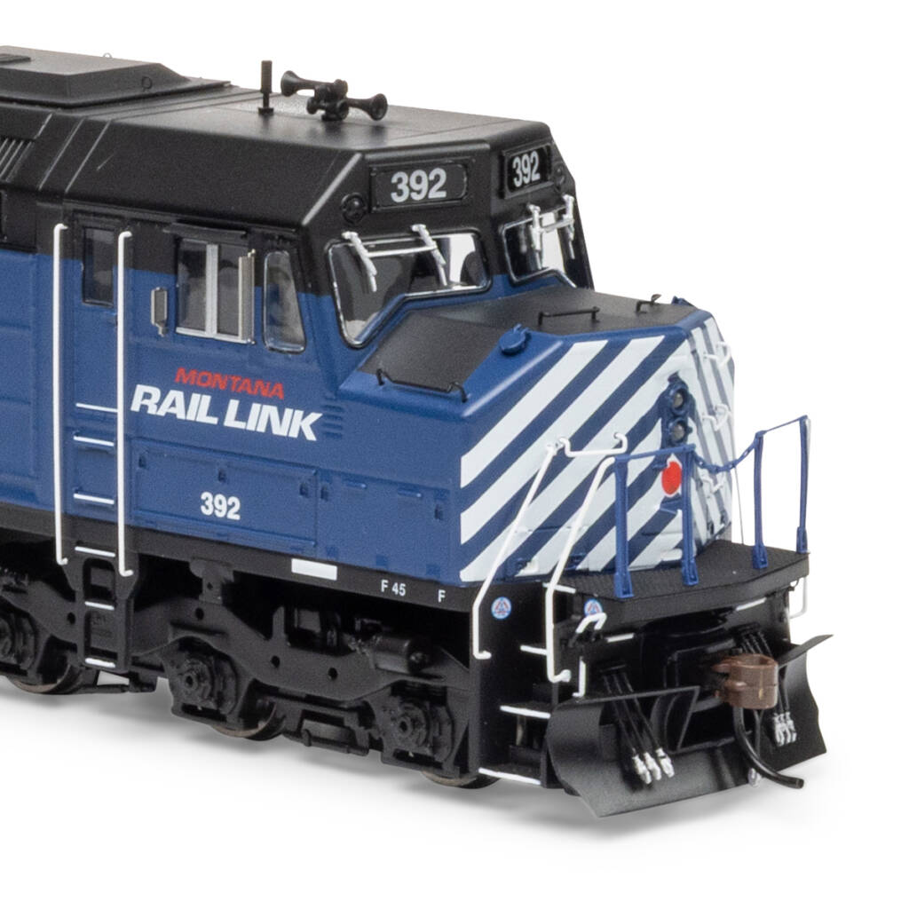 Color photo showing nose of HO scale diesel with cowl body painted dark blue and black with red and white graphics on white background