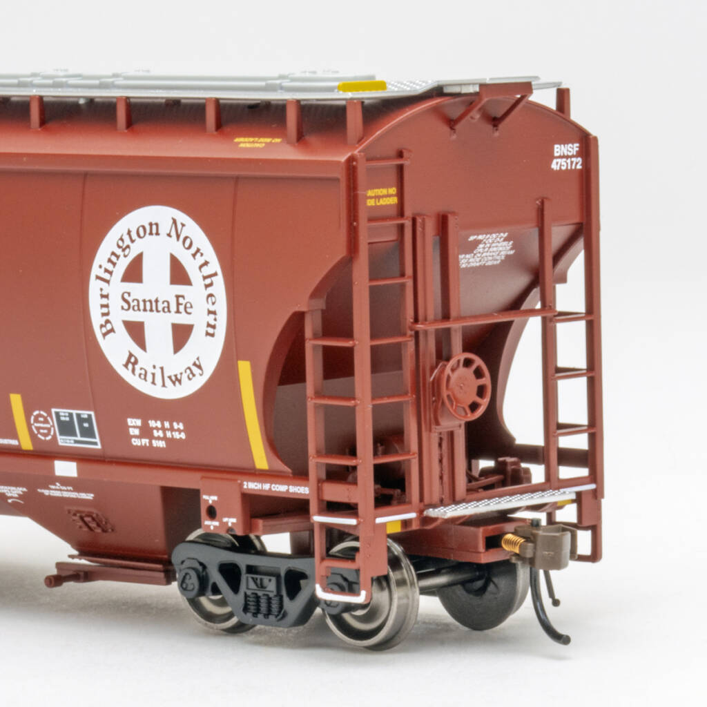 Color photo showing B end of HO scale three-bay covered hopper painted Mineral Red with white, black, and yellow graphics