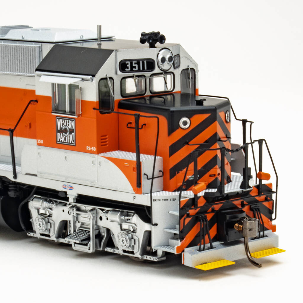 Color photo showing short hood and cab of HO scale hood unit painted aluminum, orange, and black with yellow footboards on white background.